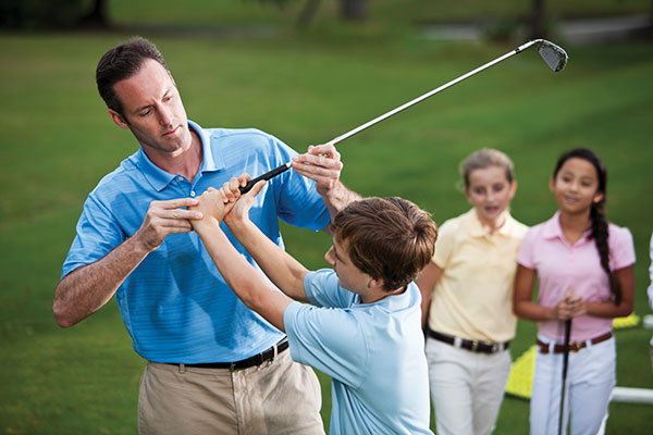 instructor teaching kids how to golf