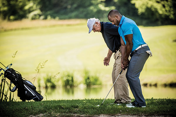 men golfing and getting lessons